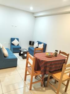 a living room with a table and chairs and a couch at Killitas home&apart in Cusco +32 photos