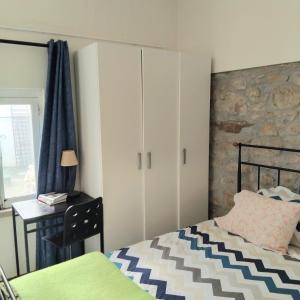 a bedroom with a bed and a desk and cabinets at Anexo na Quintinha in Caldas da Rainha