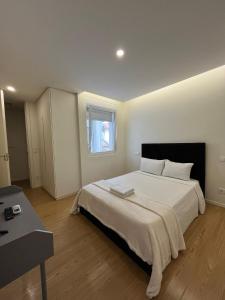 a bedroom with a large white bed and a window at Casa Augusta 4 in Braga