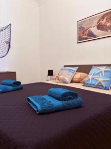 two blue pillows on a bed in a bedroom at Domus Maris in Cefalù