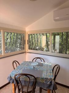 a table and chairs in a room with windows at Domus Maris in Cefalù