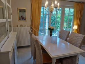 a dining room with a white table and chairs at Achtern - Diek - am Strand in Zingst