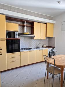 a kitchen with yellow cabinets and a wooden table at Punto Zero Ca' Trillina in La Spezia