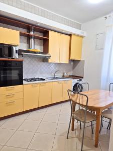a kitchen with yellow cabinets and a wooden table at Punto Zero Ca' Trillina in La Spezia