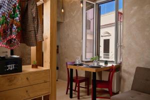 a room with a table and chairs and a window at Mamaco Trani Homey in Trani +9 photos