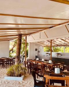 a restaurant with wooden tables and chairs under an umbrella at Island Break in Fulidhoo