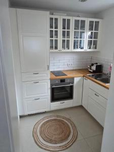 a white kitchen with white cabinets and a stove at Utting Schulstrasse in Utting am Ammersee