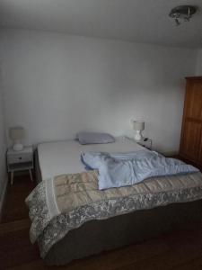 a bed in a bedroom with a white wall at Utting Schulstrasse in Utting am Ammersee