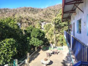 a balcony of a house with a table and benches at vishranti homestayy in Rishīkesh