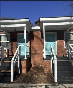 a brick house with blue doors and stairs at Cozy 1 Bedroom Bungalow in Charlotte