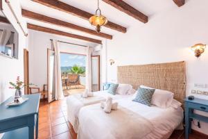 a bedroom with two beds and a blue desk at Hotel Rural Almazara in Frigiliana