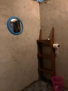 a bathroom with a mirror and a toilet paper dispenser at Nadi awin kamam in Fambemuk