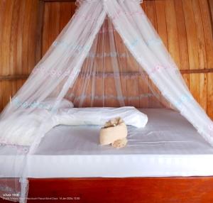 a bed with a canopy with a towel on it at Nadi awin kamam in Fambemuk