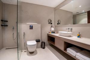 a bathroom with a toilet and a sink and a shower at Trinity Hotel Banquet & Spa in Siliguri