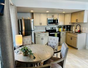 a kitchen with a wooden table and a table and chairs at The Monterey Beach Resort in St. Pete Beach