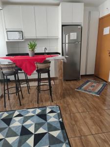 a kitchen with a table with chairs and a refrigerator at Apt confortável in Camboriú