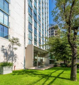 a building with a green lawn in front of a building at Nest Collection El Golf in Santiago