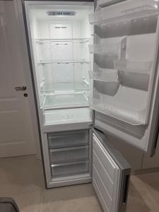 an empty refrigerator with its door open in a kitchen at KEAN Apartments in Vlorë