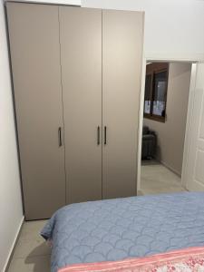 a bedroom with white cabinets and a blue bed at KEAN Apartments in Vlorë