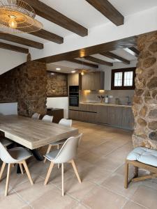 a kitchen and dining room with a wooden table and chairs at Camping Fonts del Algar in Callosa d'en Sarrià