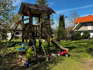 a young boy playing in a wooden play house at Järve Talu Puhkemaja in Otepää