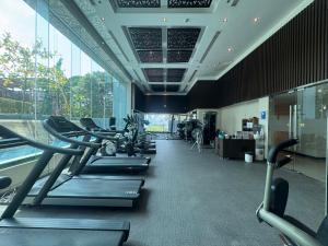 a gym with several treadmills and elliptical machines at NexStay Bangkok Appartment in Bangkok