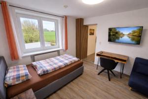 a room with a couch and a desk and a window at Speedys Bed & Breakfast in Reimerath