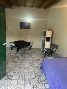 a room with a bed and chairs and a flat screen tv at Departamento Favaloro in RSA