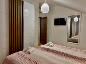 a bedroom with a large bed with towels on it at Apartments KIDS in Kaštela