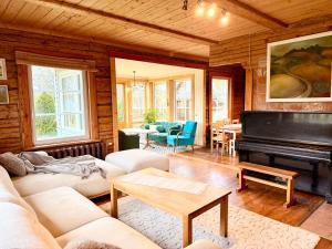 a living room with a couch and a piano at Järve Talu Puhkemaja in Otepää
