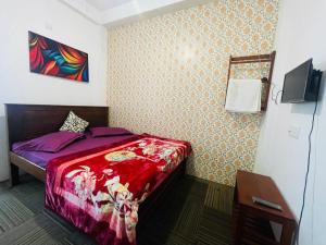 a small bedroom with a bed and a tv at Ivory guest house in Pattipola