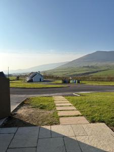 a road with a small white building on the side of the road at Dingle Lispole Garden Suite 6 in Lispole