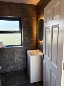 a bathroom with a sink and a window at Dingle Lispole Garden Suite 6 in Lispole