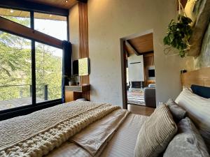 a bedroom with a large bed and a large window at Шале Ротило in Krivopolʼye