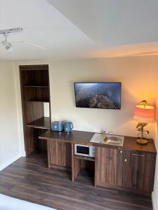 a kitchen with a desk and a sink and a tv at Dingle Lispole Garden Suite 6 in Lispole +1 photo