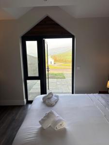 a bedroom with a bed with two towels on it at Dingle Lispole Garden Suite 6 in Lispole