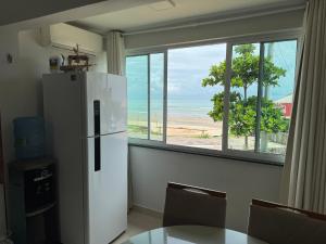 a kitchen with a refrigerator and a table and a window at Ap do Henrique in Luis Correia