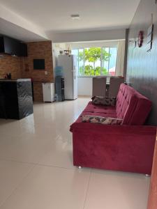 a living room with a red couch in the middle at Ap do Henrique in Luis Correia