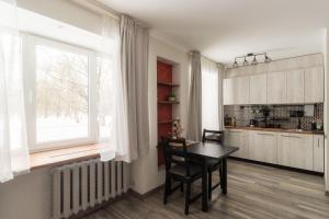 a kitchen with a dining room table and a window at Park-View Studio Apartment with Free Parking - 10 min to Old Town in Riga