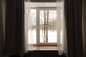 a window with a view of a snow covered field at Park-View Studio Apartment with Free Parking - 10 min to Old Town in Riga