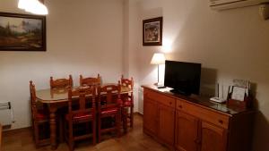 Sala de estar con mesa de comedor y TV en Apartamentos Fuente La Raja, en La Iruela