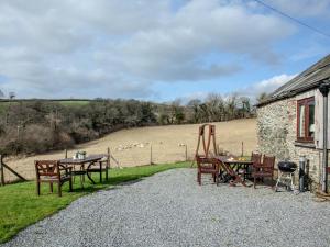 a patio with a table and chairs and a building at Tuckenhay, Edgecombe Barn- Hfu in Ashsprington +50 photos