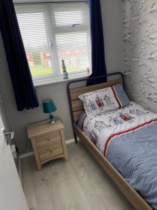 a small bedroom with a bed and a night stand at 114 Bermuda in Hemsby
