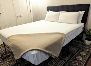 a bed with a black headboard and white sheets and pillows at Modern Downtown Loft Walk to Convention Center in Richmond