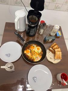 a table with a pan of eggs and bread on it at hostel of sincerity Female only in Maharagama +10 photos