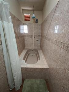 a bathroom with a bath tub with a shower at Casas de Qlí in Santiago Atitlán