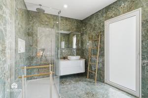a bathroom with a shower and a sink and a mirror at Atlantic Apartments in Santa Cruz +56 photos