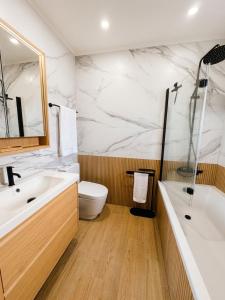 a bathroom with a sink and a toilet and a tub at Pico Island Villas 38 - Private Atlantic Retreat in Santo António +12 photos
