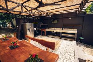 a large kitchen with a wooden table and a counter at Santa Toro Inn, private rooms close to the beach in Santa Teresa Beach