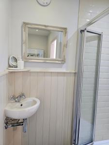 a bathroom with a sink and a mirror at The Wee Corsee Cosy Coastal Cottage in the Heart of Nairn in Nairn